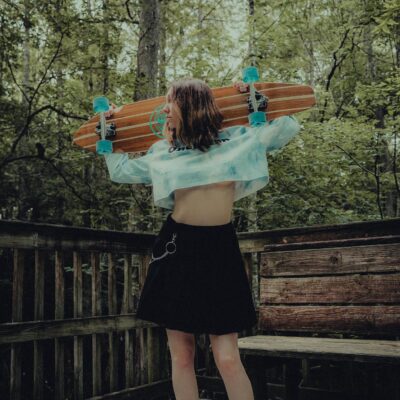 A girl holding a surfboard on a deck